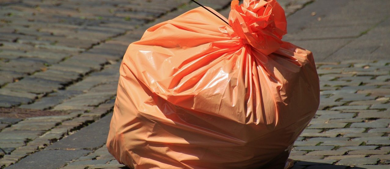 Pomarańczowa torba na śmieci na ulicy