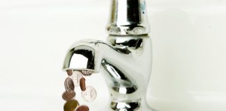 Money flowing out of a retro bathroom tap.