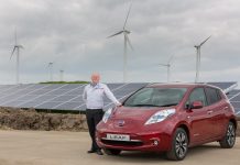 Samochód Nissan Leaf przed zasilaną panelami słonecznymi fabryką Nissan w Sunderland.