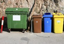 Multiple plastic recycling container bins on street in village
