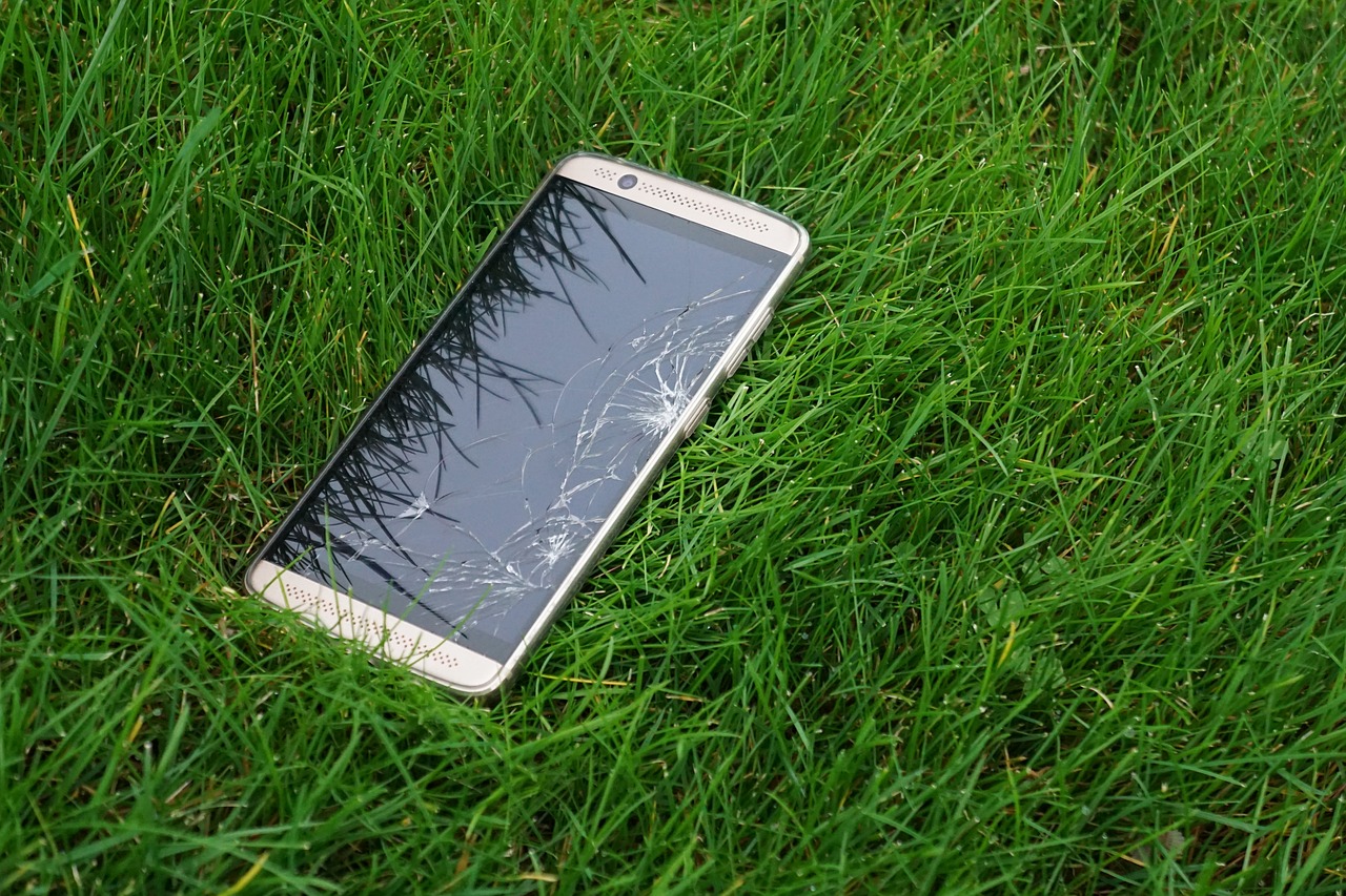 Rozstrzaskany smartfon na trawie