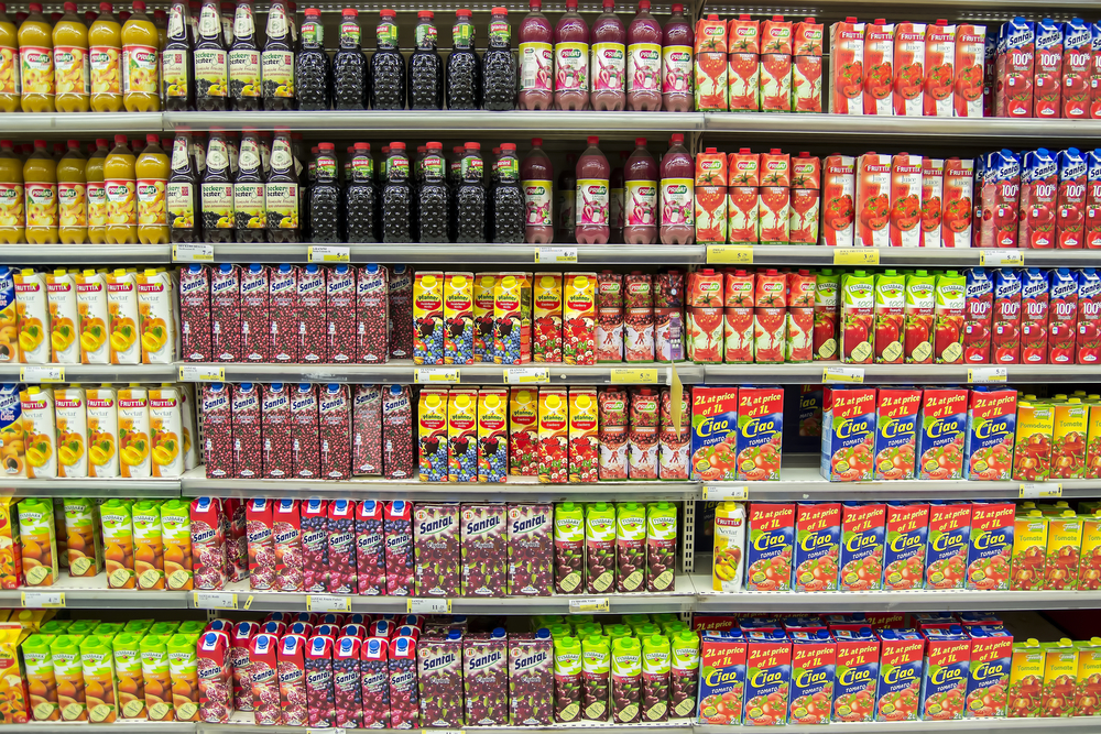 Kolorowe kartony i butelki z napojami na półkach w supermarkecie