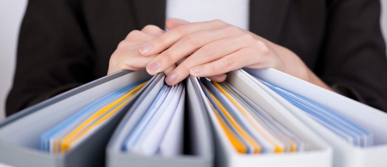 Midsection of businesswoman with binders at office