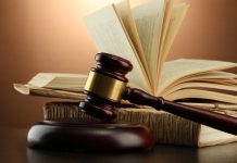 wooden gavel and books on wooden table,on brown background